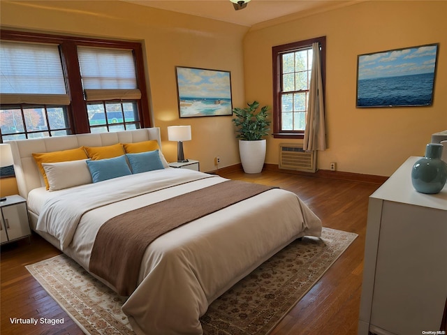 bedroom featuring a wall mounted air conditioner and dark wood-type flooring