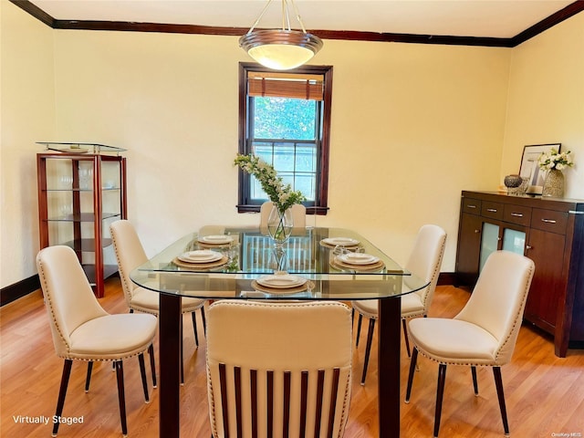 dining area with light hardwood / wood-style floors and ornamental molding