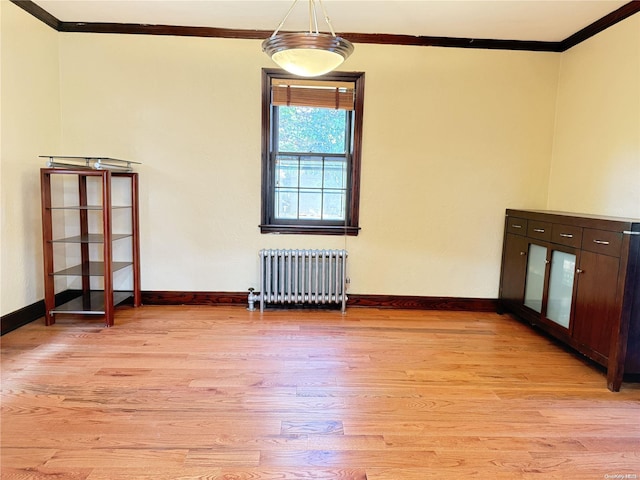 unfurnished room featuring radiator, crown molding, and light hardwood / wood-style flooring