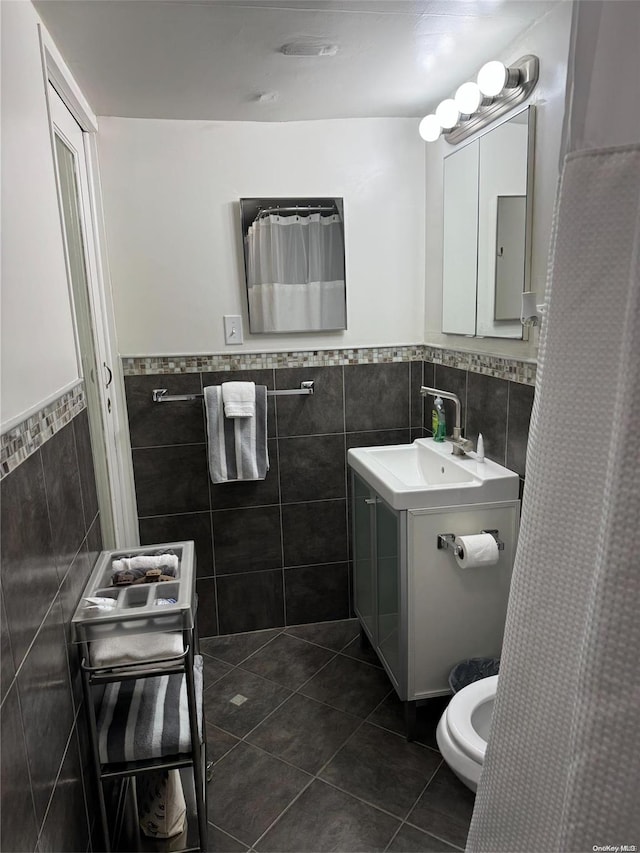 147 E 29th St, Brooklyn, NY 11226 - full bathroom featuring tile walls, tile patterned flooring, wainscoting, toilet, and vanity