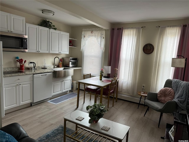 147 E 29th St, Brooklyn, NY 11226 - kitchen featuring dishwashing machine, stainless steel microwave, light countertops, white cabinets, and light wood-type flooring