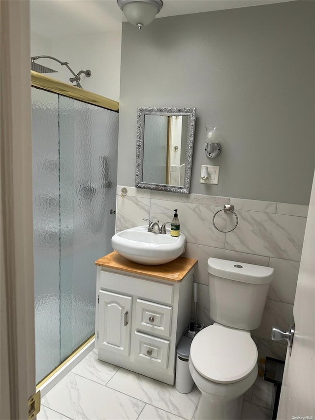 147 E 29th St, Brooklyn, NY 11226 - bathroom featuring a stall shower, vanity, tile walls, toilet, and wainscoting