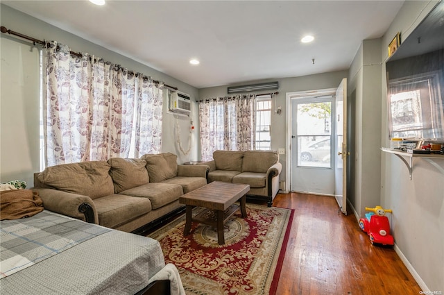 living room with a wall mounted AC and dark wood-type flooring