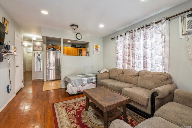 living room featuring dark hardwood / wood-style floors and a wall unit AC