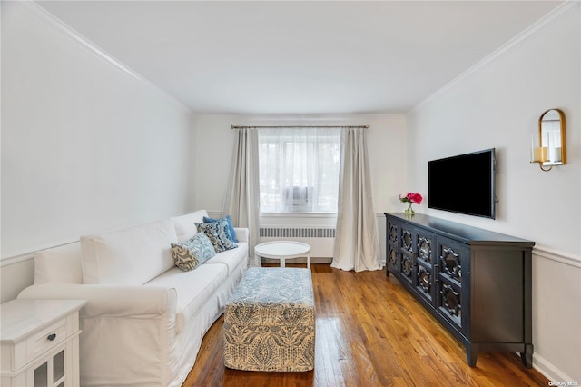 living room with radiator heating unit, ornamental molding, and hardwood / wood-style floors