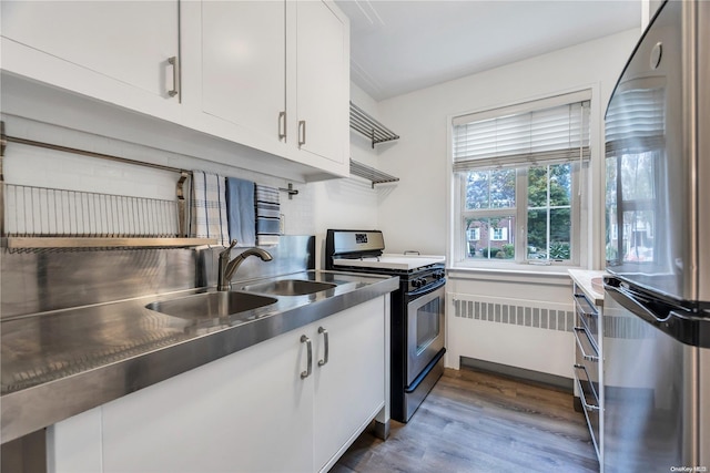 kitchen featuring appliances with stainless steel finishes, dark hardwood / wood-style floors, white cabinetry, and stainless steel counters