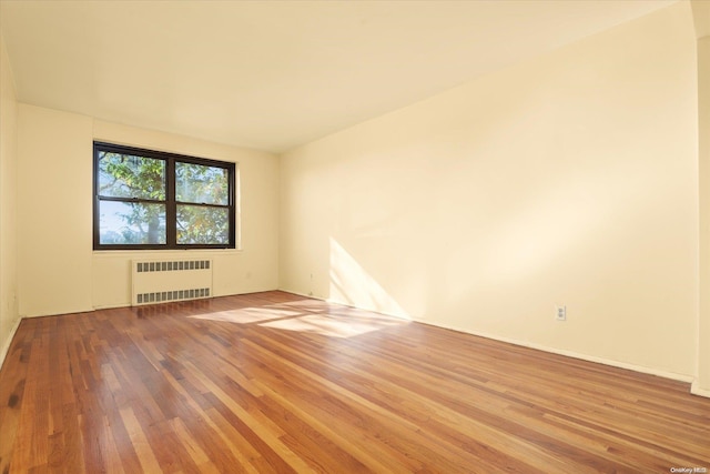 spare room with radiator and hardwood / wood-style floors