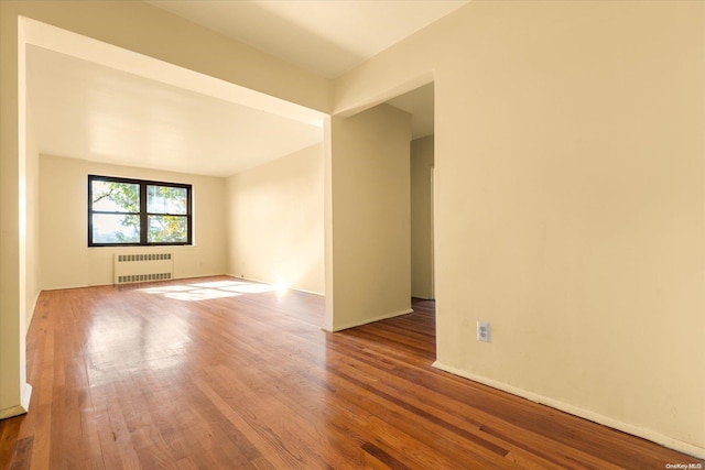 unfurnished room featuring radiator and wood-type flooring