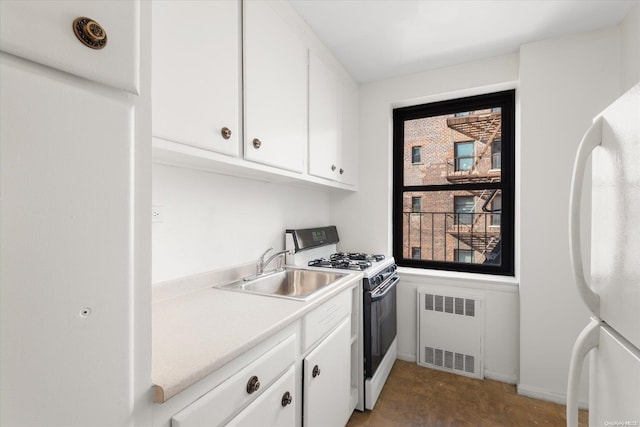 kitchen with white cabinetry, white appliances, sink, and radiator