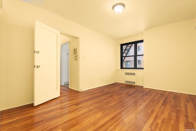 empty room featuring hardwood / wood-style flooring and radiator