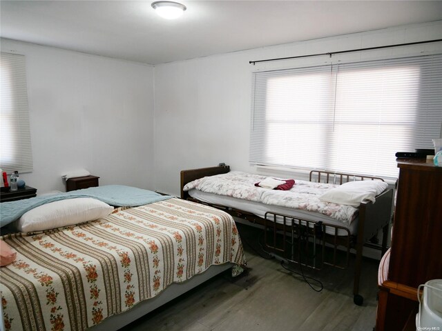 bedroom with a baseboard radiator and dark hardwood / wood-style floors