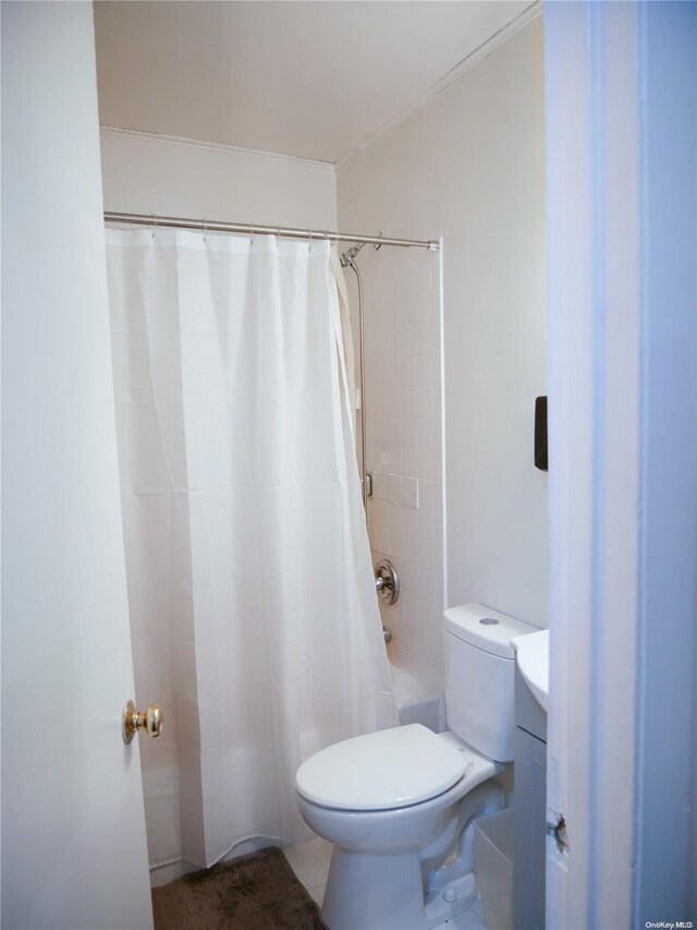 bathroom featuring tile patterned flooring, toilet, and shower / bath combo with shower curtain