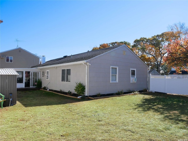 back of house with a lawn and a sunroom