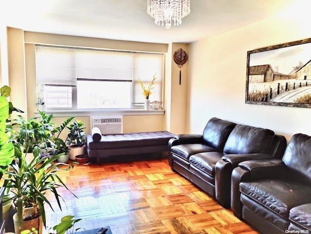 living room with light parquet floors, a wall unit AC, and an inviting chandelier