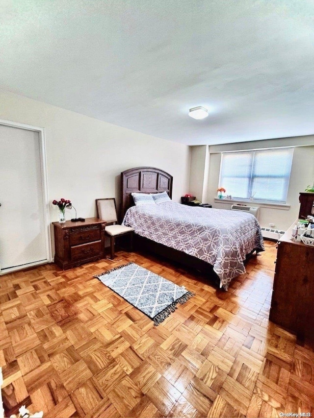 bedroom featuring light parquet floors and a baseboard heating unit