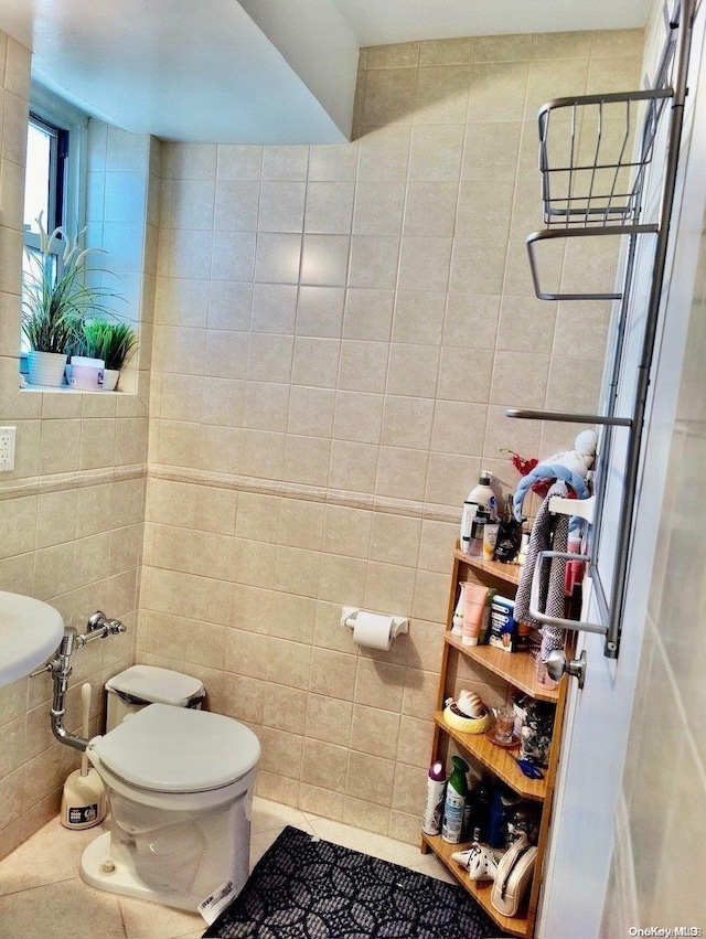 bathroom featuring tile patterned flooring, tile walls, and toilet