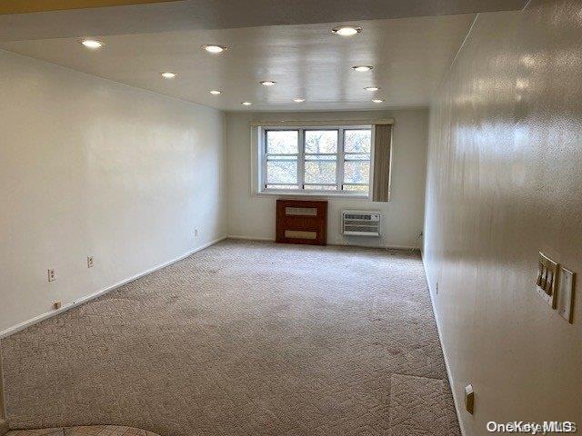 empty room with light carpet and a wall unit AC