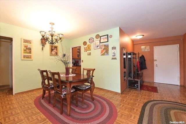 dining space with light parquet floors and an inviting chandelier