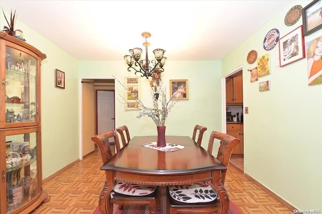 dining room with light parquet floors and a chandelier