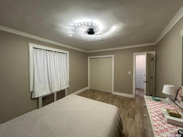 bedroom featuring wood-type flooring, crown molding, and a closet