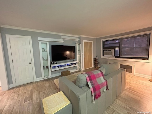 living room featuring cooling unit, ornamental molding, and light wood-type flooring