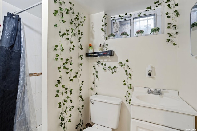 bathroom with curtained shower, vanity, and toilet