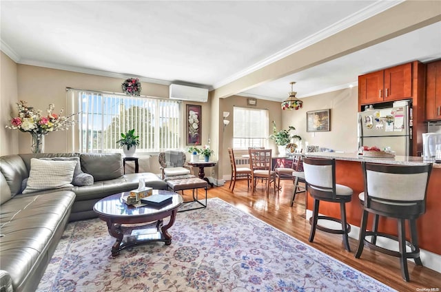 living room with hardwood / wood-style flooring, a healthy amount of sunlight, a wall mounted air conditioner, and ornamental molding