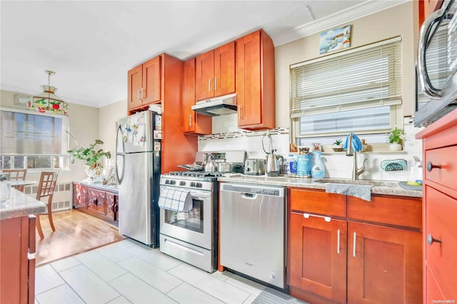 kitchen with light stone countertops, sink, backsplash, appliances with stainless steel finishes, and ornamental molding