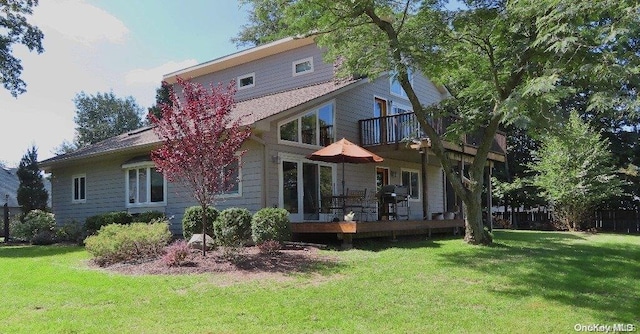 rear view of property with a deck and a yard