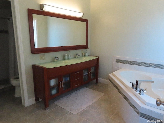 bathroom featuring tile patterned floors, vanity, toilet, and tiled tub