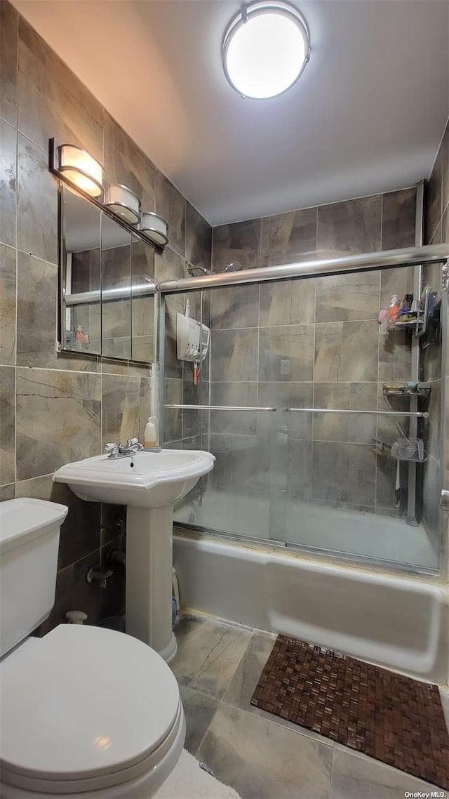 bathroom featuring toilet, tile walls, and enclosed tub / shower combo