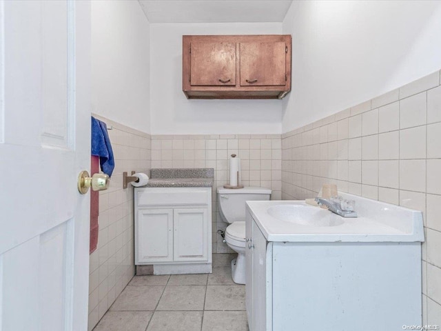 bathroom featuring tile patterned floors, vanity, tile walls, and toilet