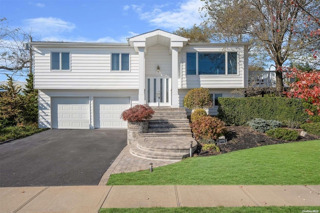 bi-level home featuring a front yard and a garage