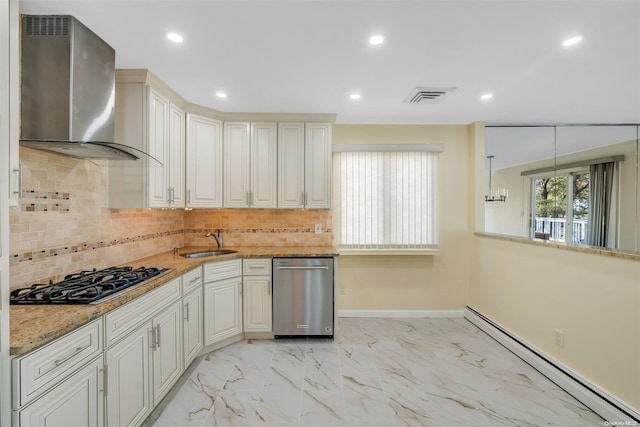 kitchen with decorative backsplash, stainless steel appliances, a baseboard heating unit, sink, and wall chimney range hood