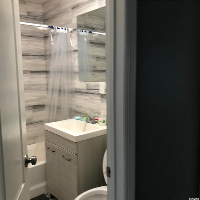 full bathroom featuring shower / bath combination with curtain, vanity, and toilet