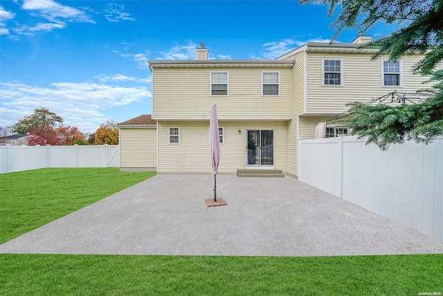 back of property with a lawn and a patio