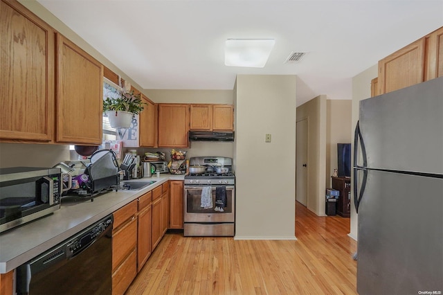 kitchen featuring light wood-type flooring, sink, and appliances with stainless steel finishes