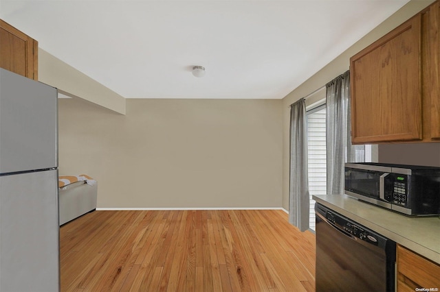 kitchen featuring black dishwasher, white fridge, and light hardwood / wood-style floors