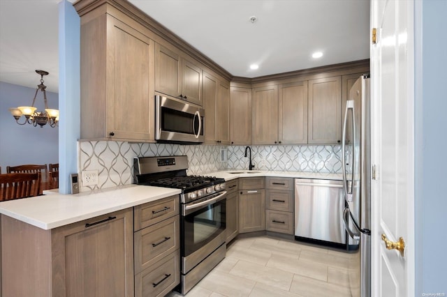 kitchen featuring hanging light fixtures, sink, appliances with stainless steel finishes, tasteful backsplash, and a notable chandelier