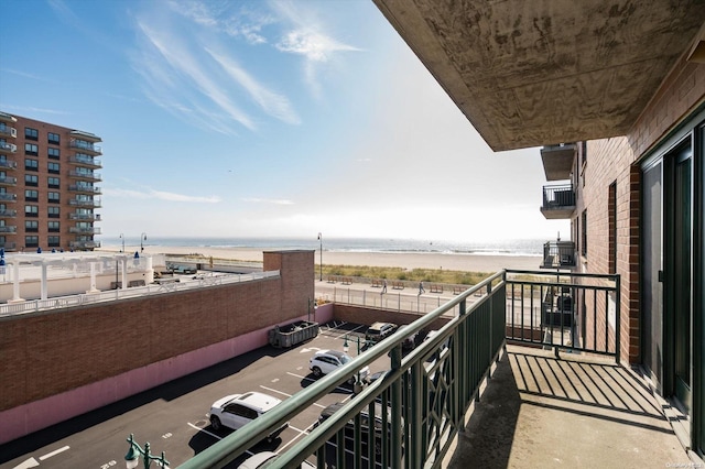 balcony with a water view and a beach view