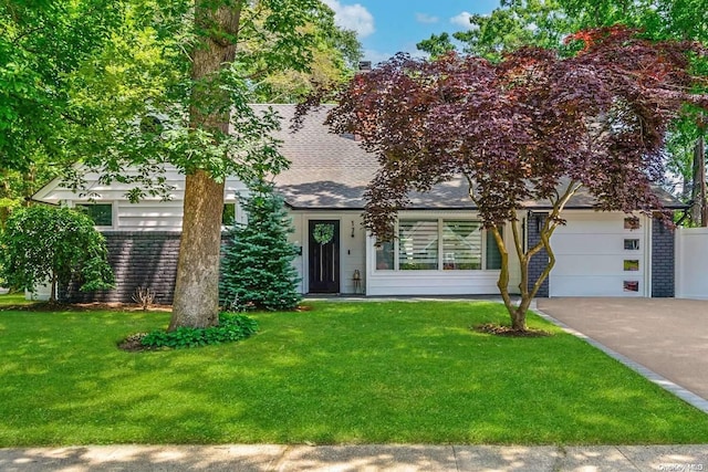 view of front of property featuring a front lawn and a garage