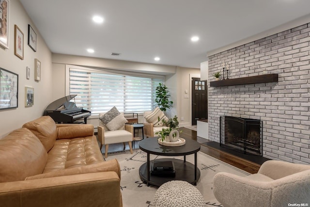 living room featuring hardwood / wood-style floors, a brick fireplace, and brick wall