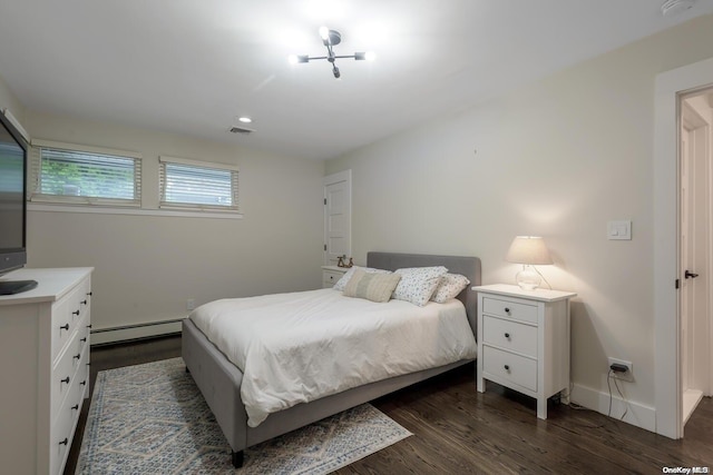 bedroom featuring dark wood-type flooring and a baseboard heating unit