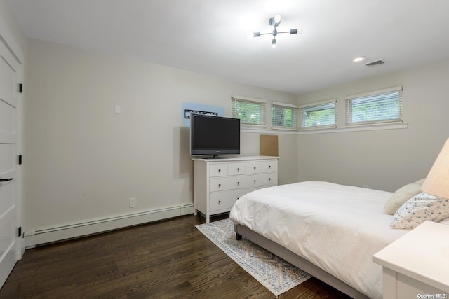 bedroom featuring dark hardwood / wood-style flooring and a baseboard heating unit