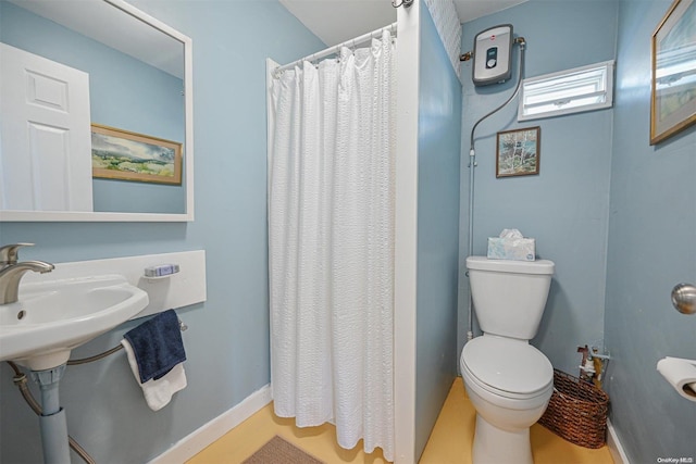 bathroom with curtained shower, toilet, and sink