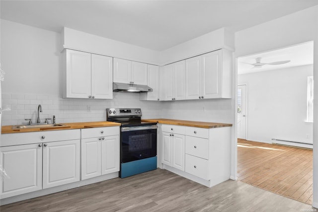 kitchen featuring white cabinets, butcher block countertops, stainless steel range with electric cooktop, and sink