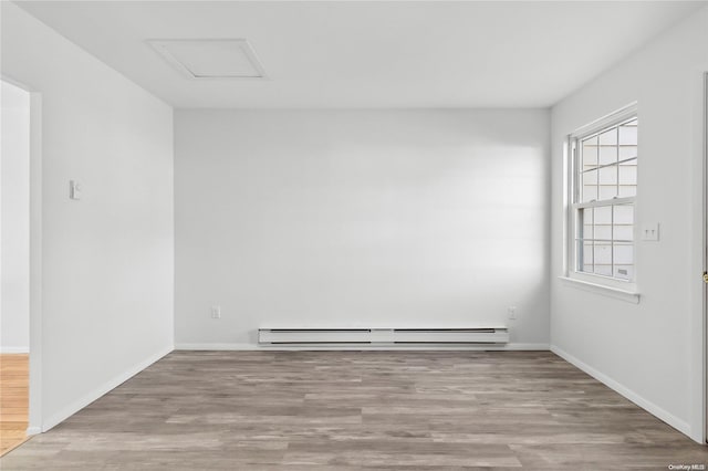 unfurnished room featuring light hardwood / wood-style floors and a baseboard radiator