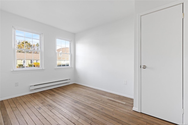 spare room featuring light wood-type flooring and a baseboard heating unit