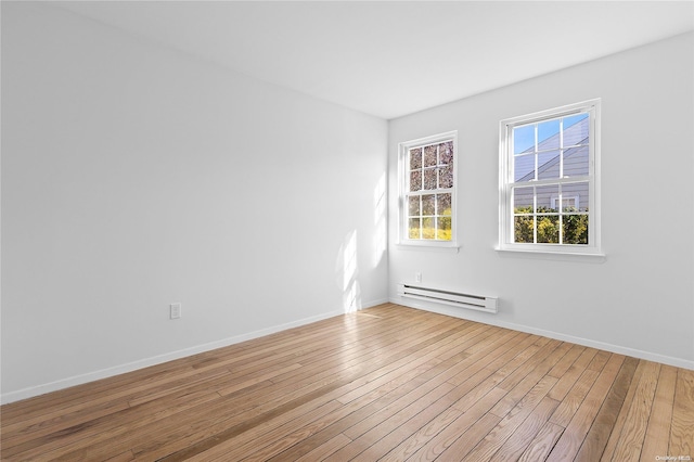 spare room featuring a baseboard radiator and wood-type flooring