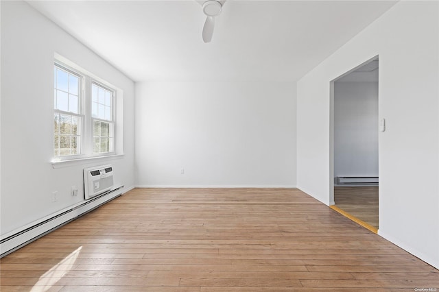 spare room featuring a wall mounted air conditioner, ceiling fan, a baseboard radiator, and light hardwood / wood-style flooring